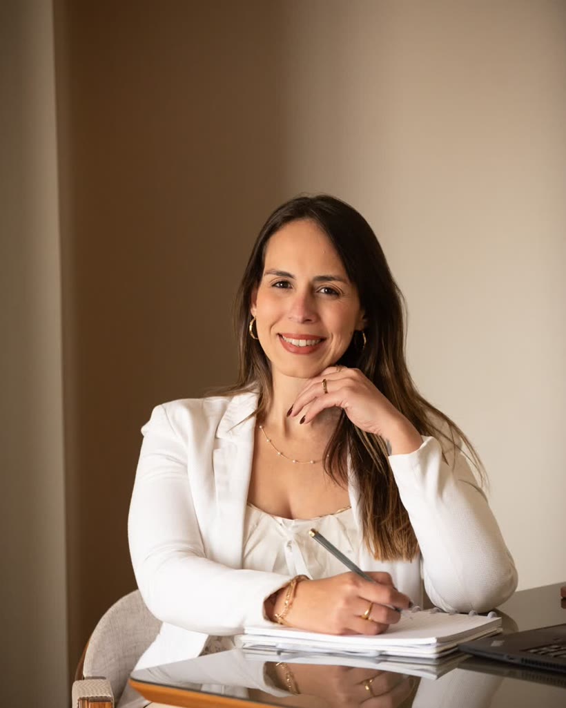 Júlia Kulexar, psicóloga, em pé, de braços cruzados